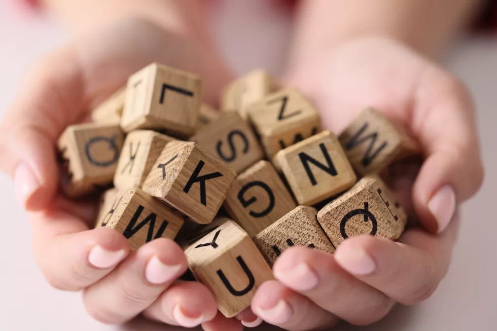full-set-wooden-cubes-with-letters-palms-closeup-alphabetical-training-set-fonts