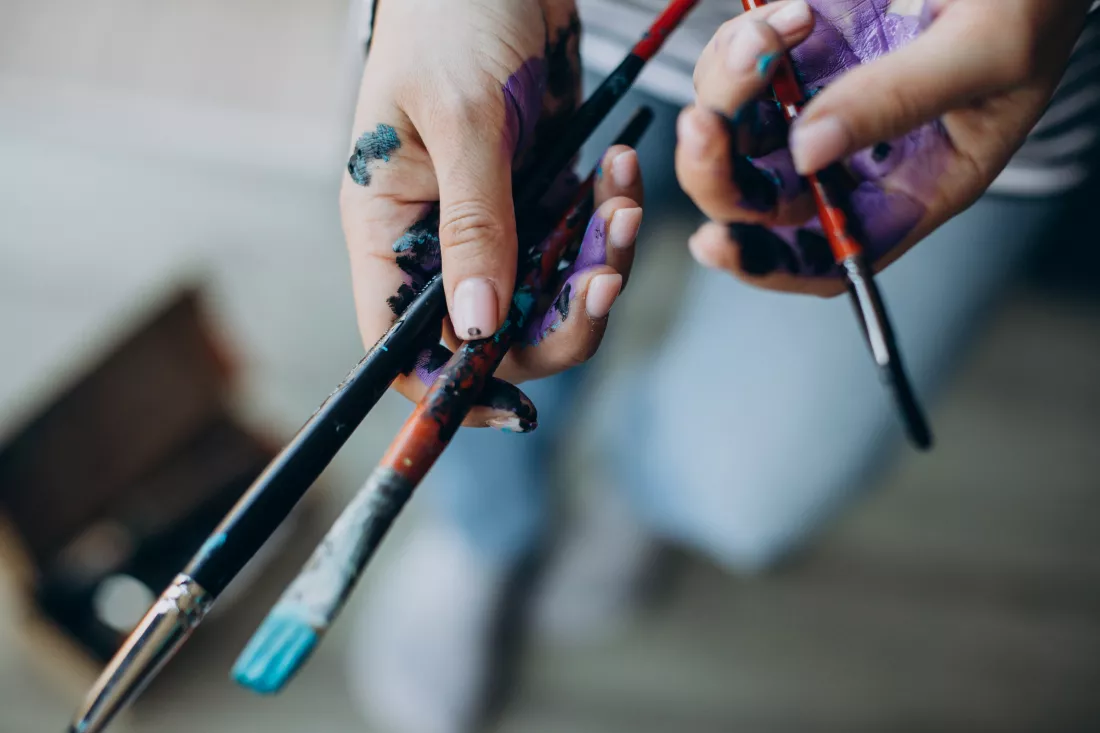 female-hands-with-painting-brushes