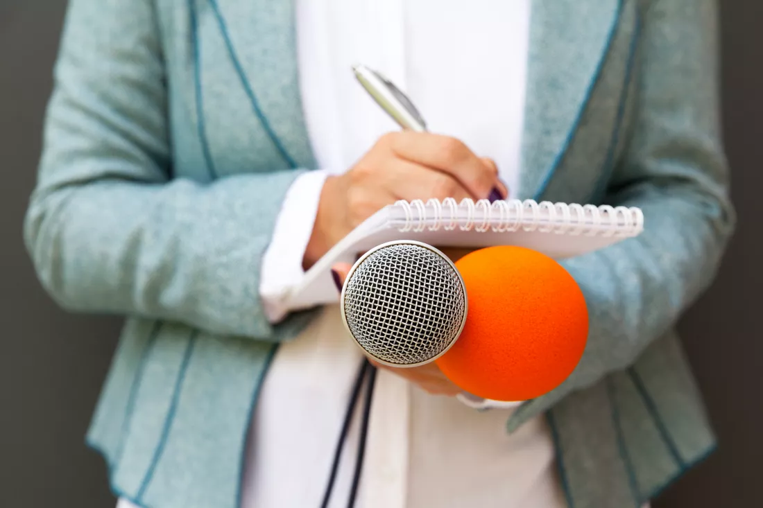 midsection-journalist-holding-microphones