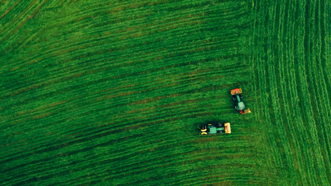 aerial-view-green-farmland-with-tractors-european-landscape
