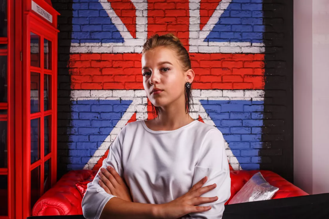 fashion-glamorous-portrait-girl-model-with-white-sweater-wall-background-with-british-flag