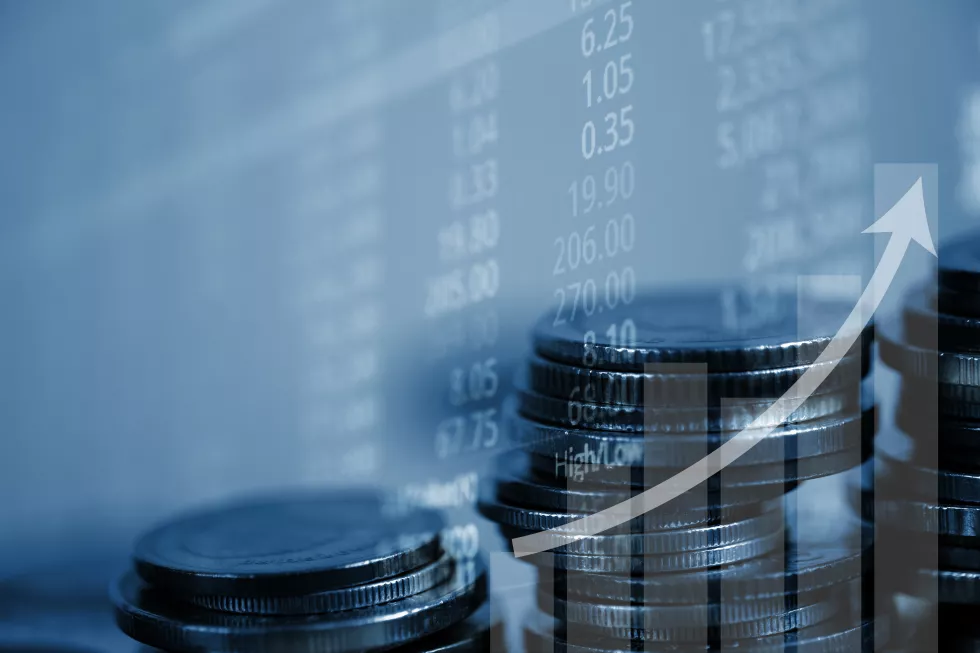 double-exposure-coin-stack-with-stock-market-screen