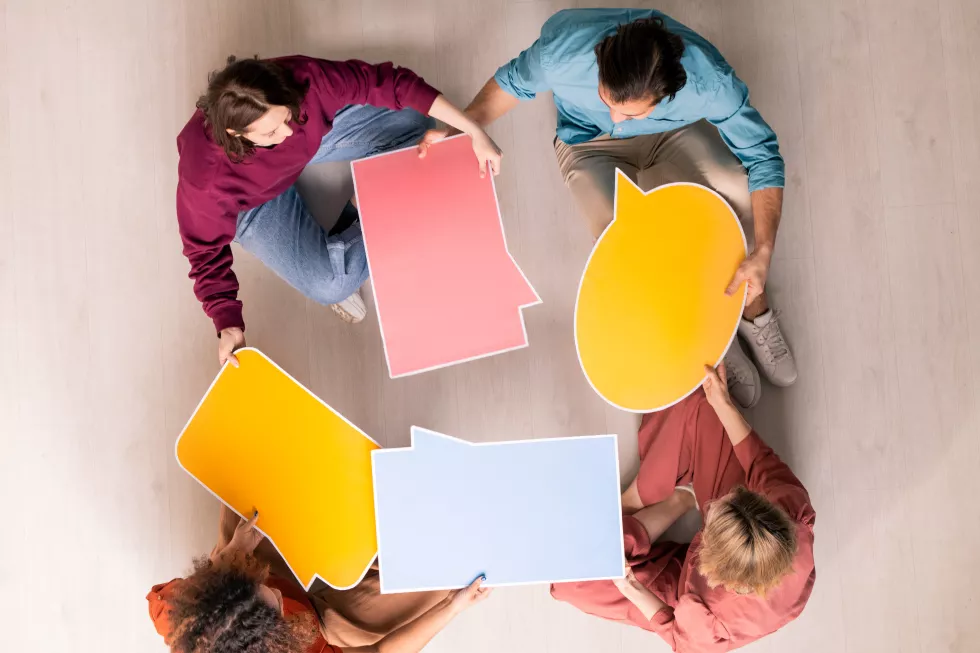 view-four-young-friendly-web-designers-casualwear-choosing-form-speech-bubble-social-networks-customer-websites