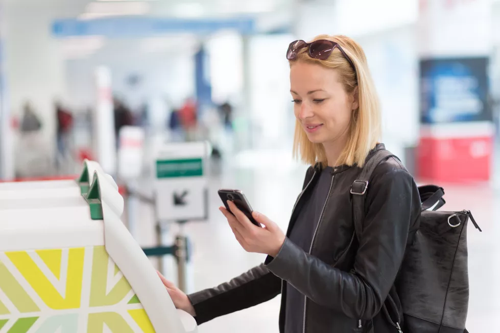 beautiful-woman-standing-by-atm-machine-airport