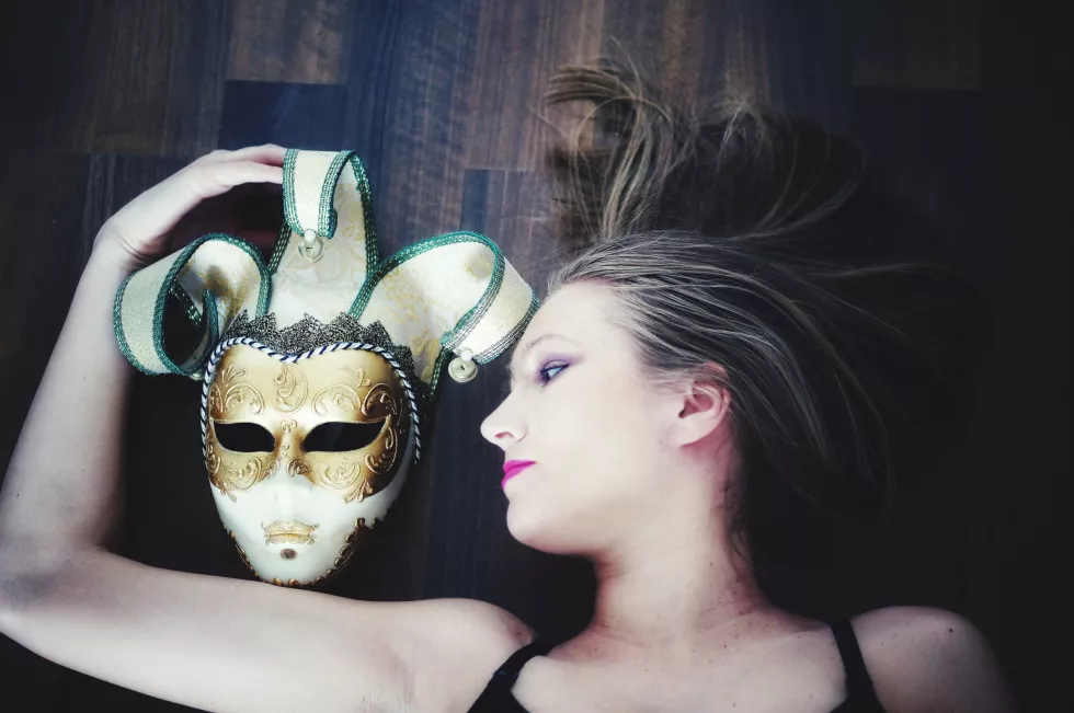 directly-shot-beautiful-woman-lying-down-by-mask-hardwood-floor