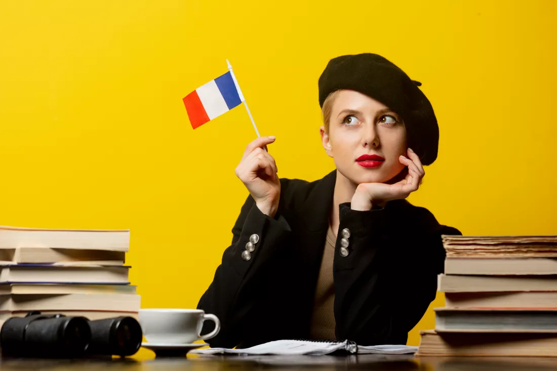 style-blonde-woman-beret-with-french-flag-books-around-yellow