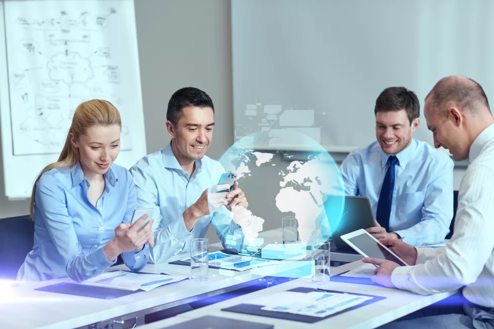 business-people-cooperation-technology-concept-smiling-business-team-with-gadgets-globe-hologram-meeting-office(1)