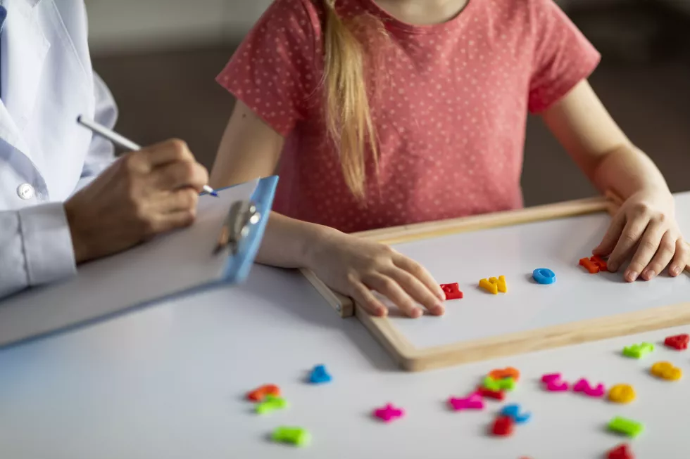 little-girl-exercising-with-alphabet-board-session-with-child-development-specialist