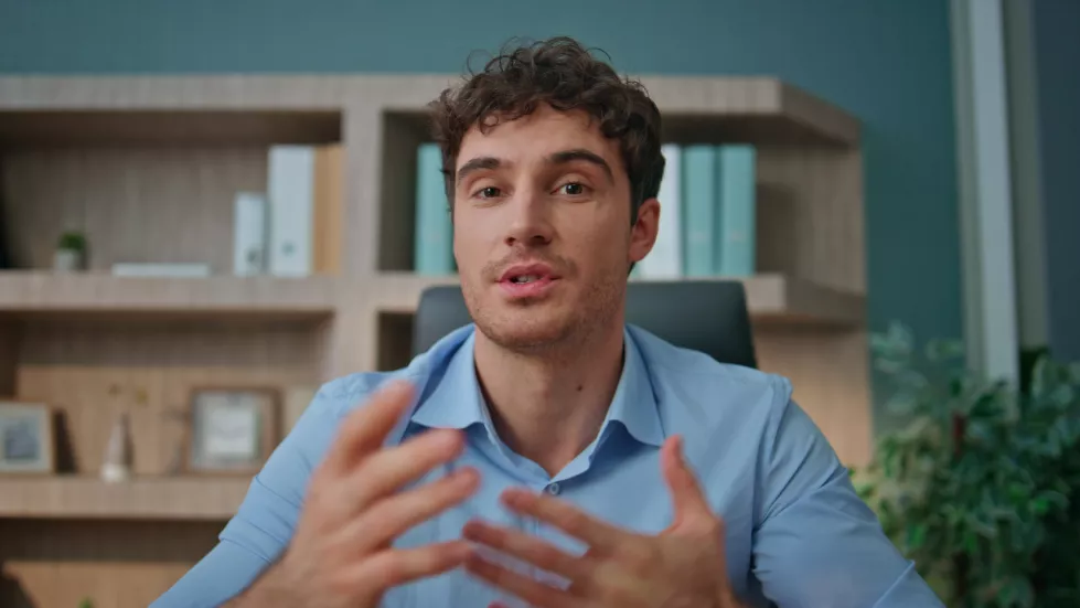pov-entrepreneur-talking-camera-interview-office-online-coach-waving-hand