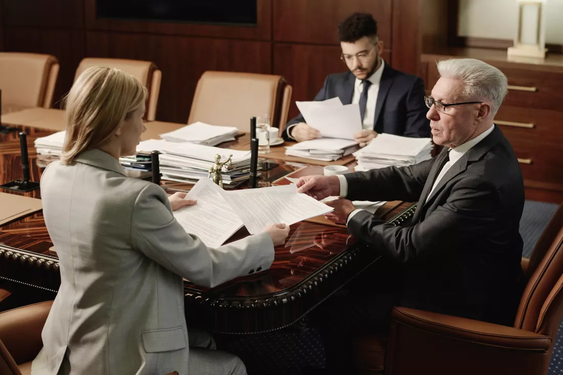 biracial-group-attorneys-working-with-documents-sitting-office-table