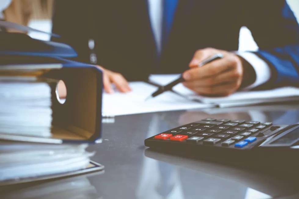 binders-with-papers-waiting-be-processed-with-businessman-bookkeeper-back-blur-accounting-planning-budget-audit-insurance-business-concept