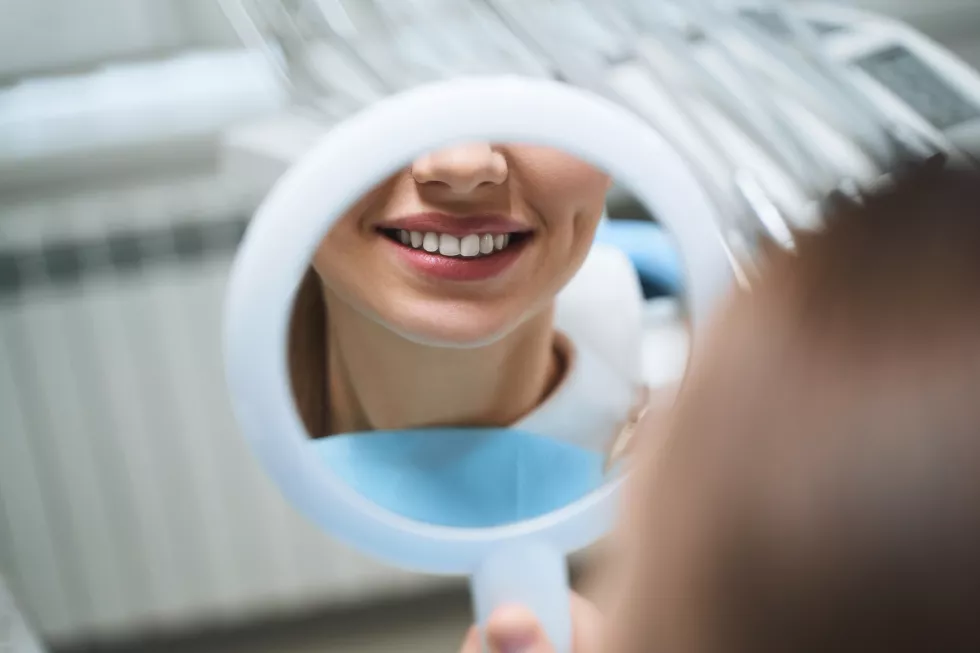 cheerful-young-girl-is-visiting-dental-clinic-looking-reflection-her-smile-after-treatment