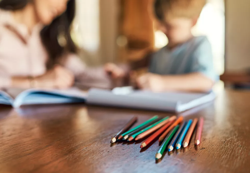 mother-child-blur-with-color-pencils-education-support-care-preschool-learning-growth-woman-son-helping-with-homework-table-teaching-drawing-skills-development