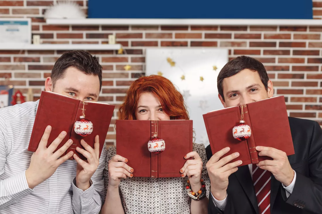 people-holding-books-hands-while-looking-camera-hiding-fac