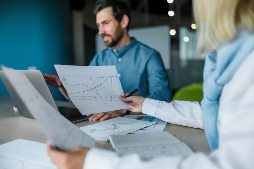 man-woman-are-sitting-table-with-graph-that-says-financial-graph
