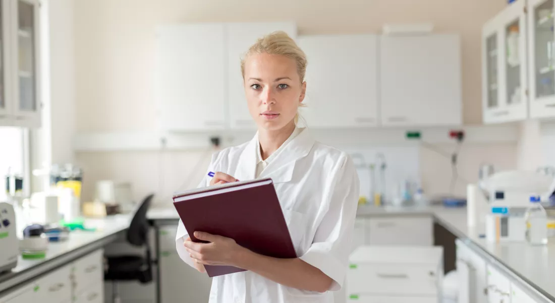 portrait-woman-writing-book-standing-laboratory