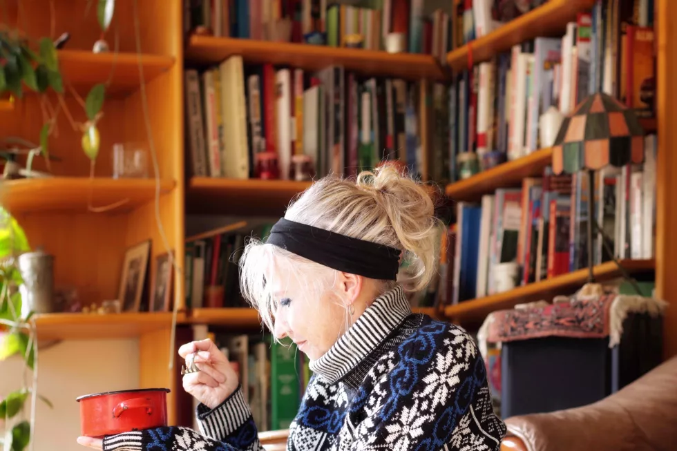 senior-woman-sitting-against-book-shelf-home