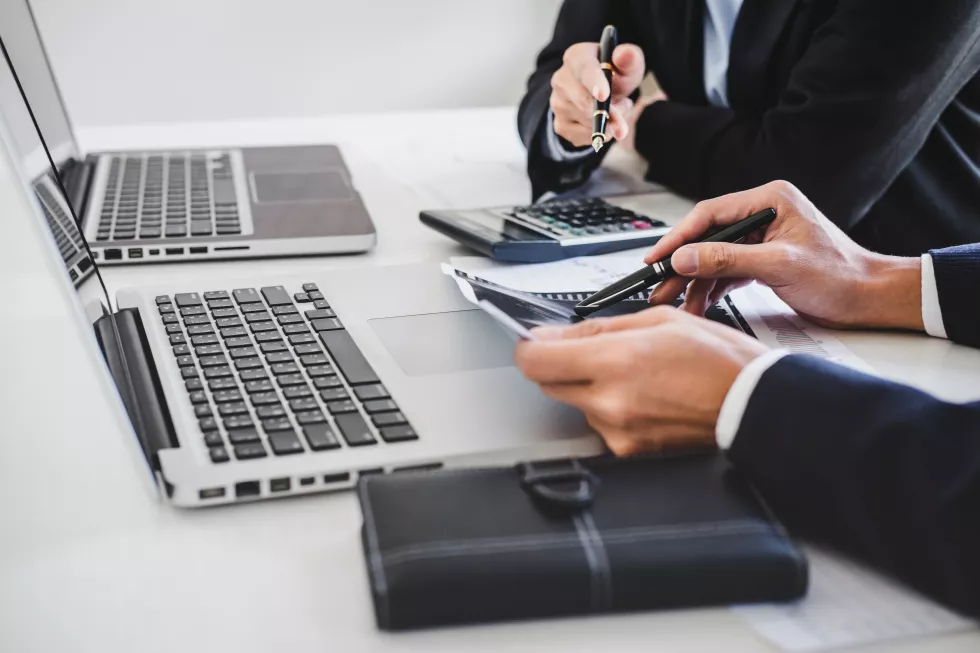 cropped-hands-businessmen-working-table(1)