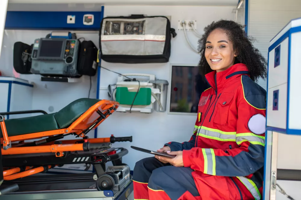smiling-happy-paramedic-with-tablet-her-hands-sitting-medical-emergency-vehicle
