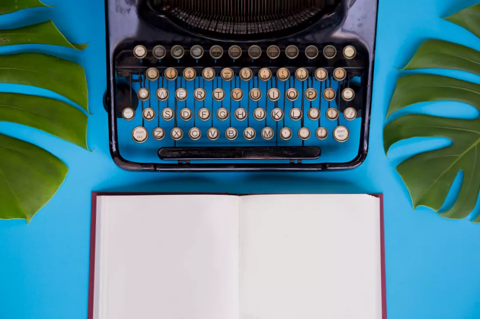 close-up-typewriter-book-against-blue-background