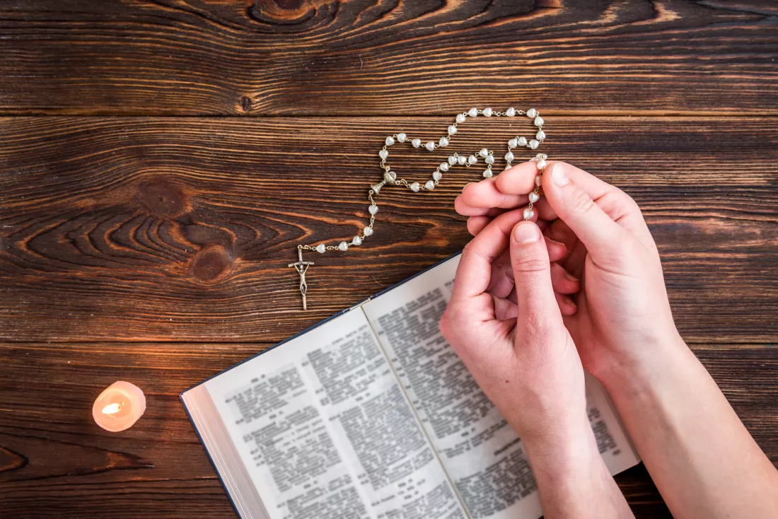open-bible-candle-christian-cross-human-hands-wooden