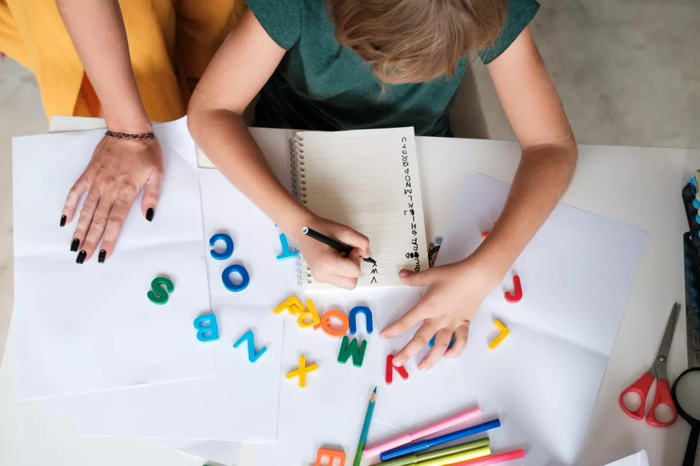 top-view-table-hands-mother-son-from-preparatory-school