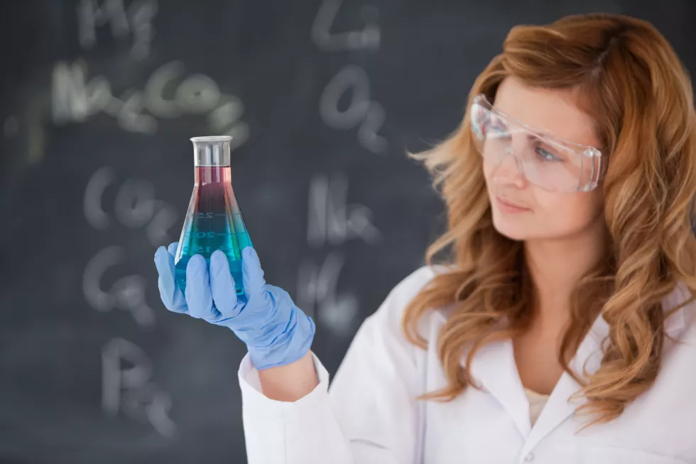 young-female-scientist-looking-red-blue-flask