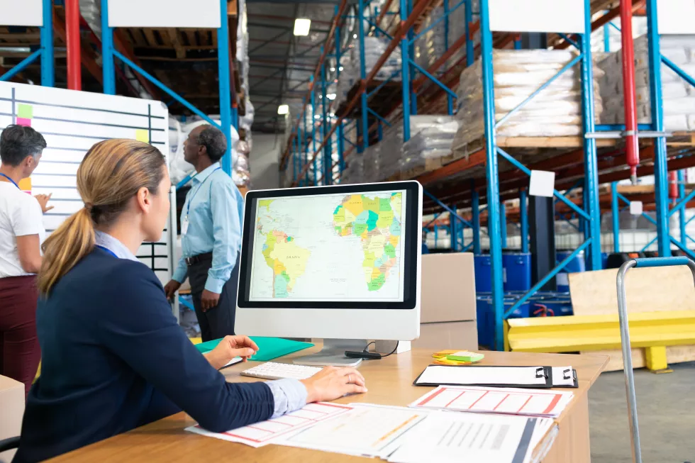female-manager-working-computer-desk-warehouse