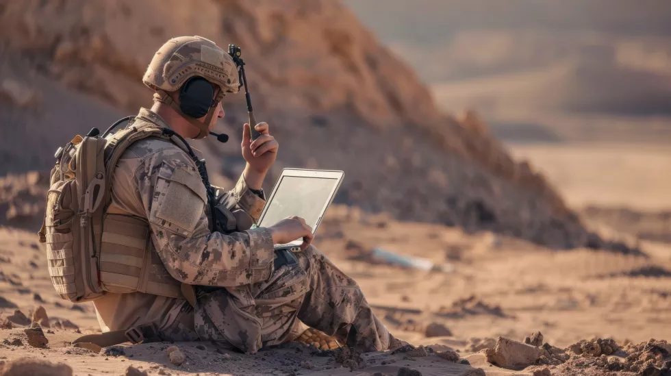 soldier-is-sitting-ground-with-laptop-front-him