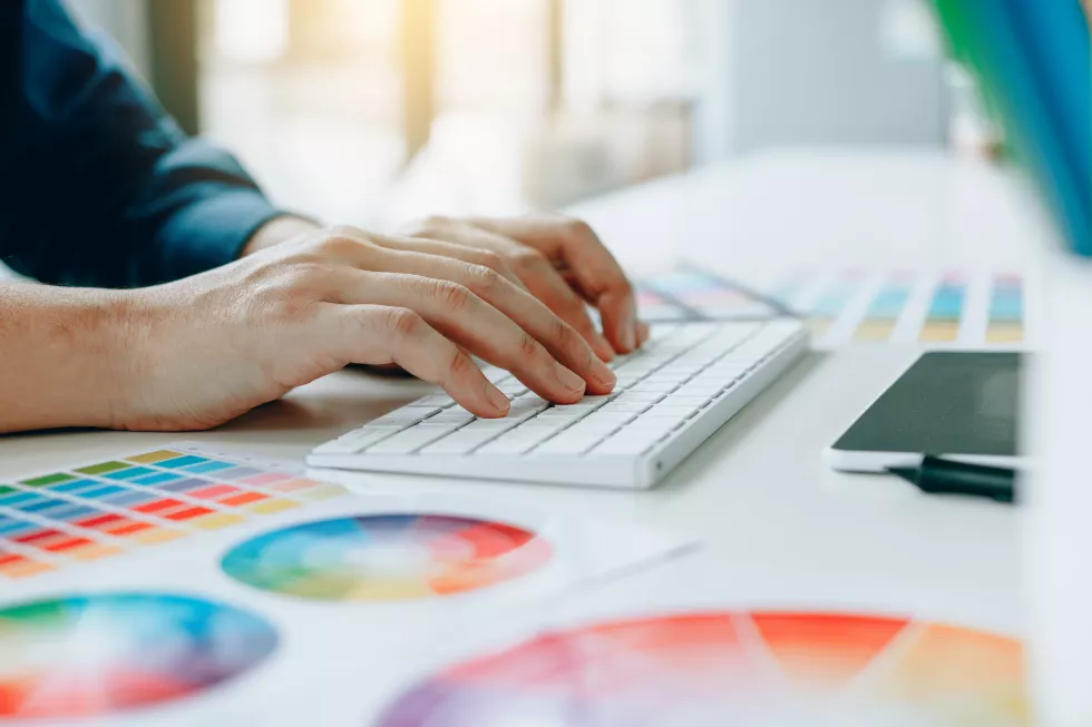 close-up-design-professional-using-computer-with-color-swatches-table-office
