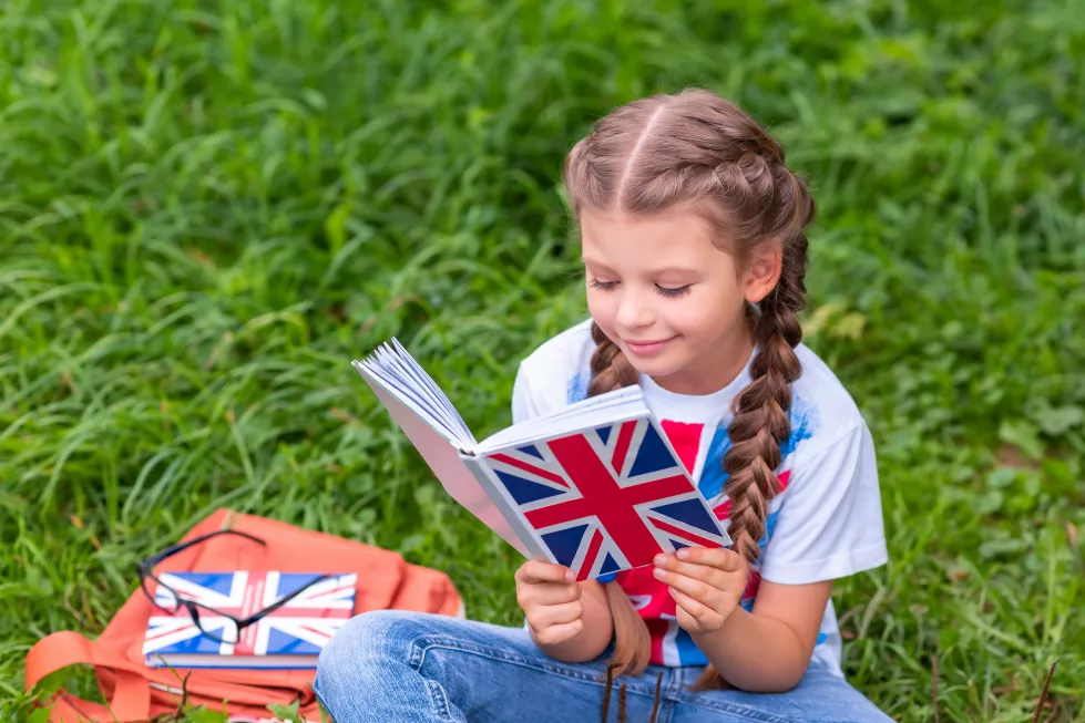 little-girl-is-studying-book-english-language-sitting-lawn