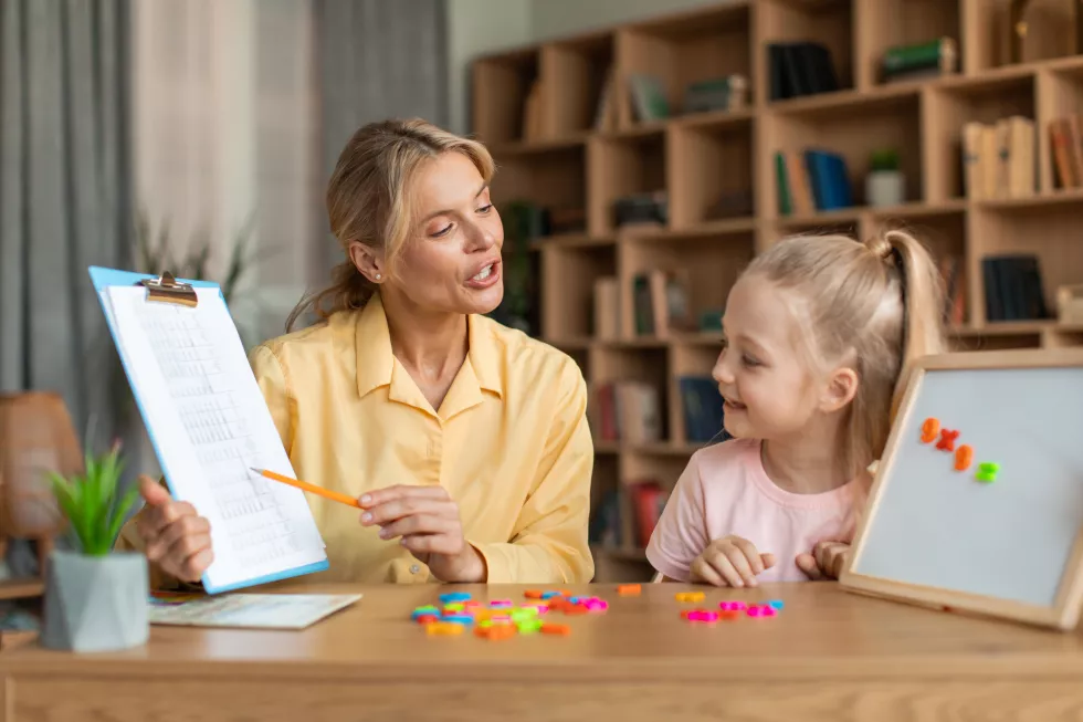 professional-female-teacher-exercising-with-clever-preschool-girl-little-child-counting-repeating-words-numbers