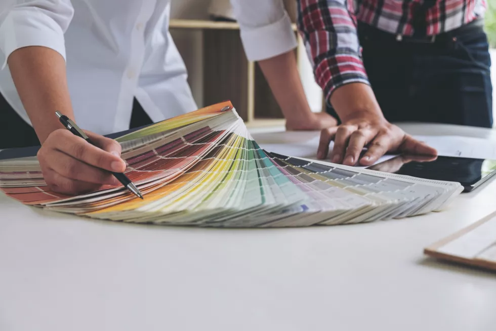 midsection-business-colleagues-choosing-color-swatch